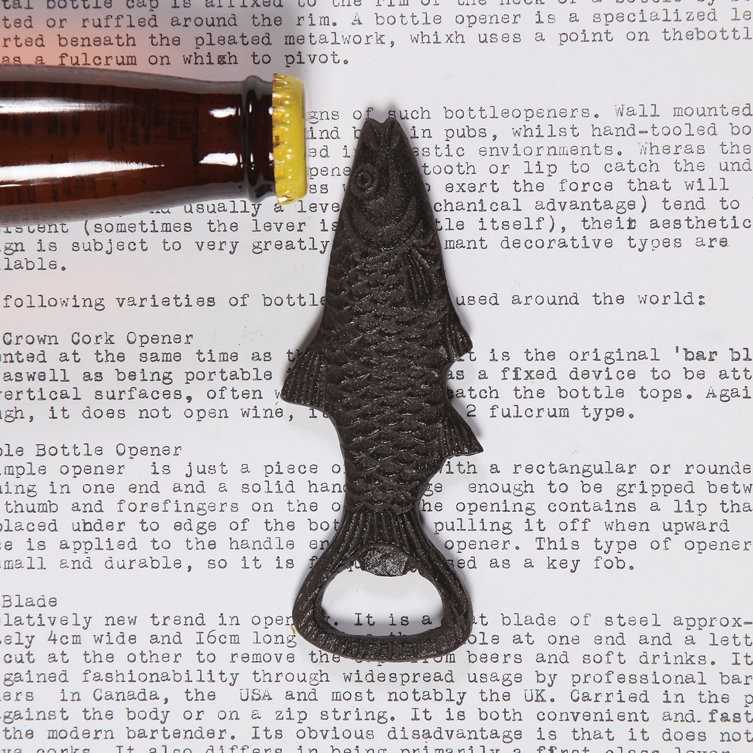 Image of a cast iron fish bottle opener next to a beer bottle.
